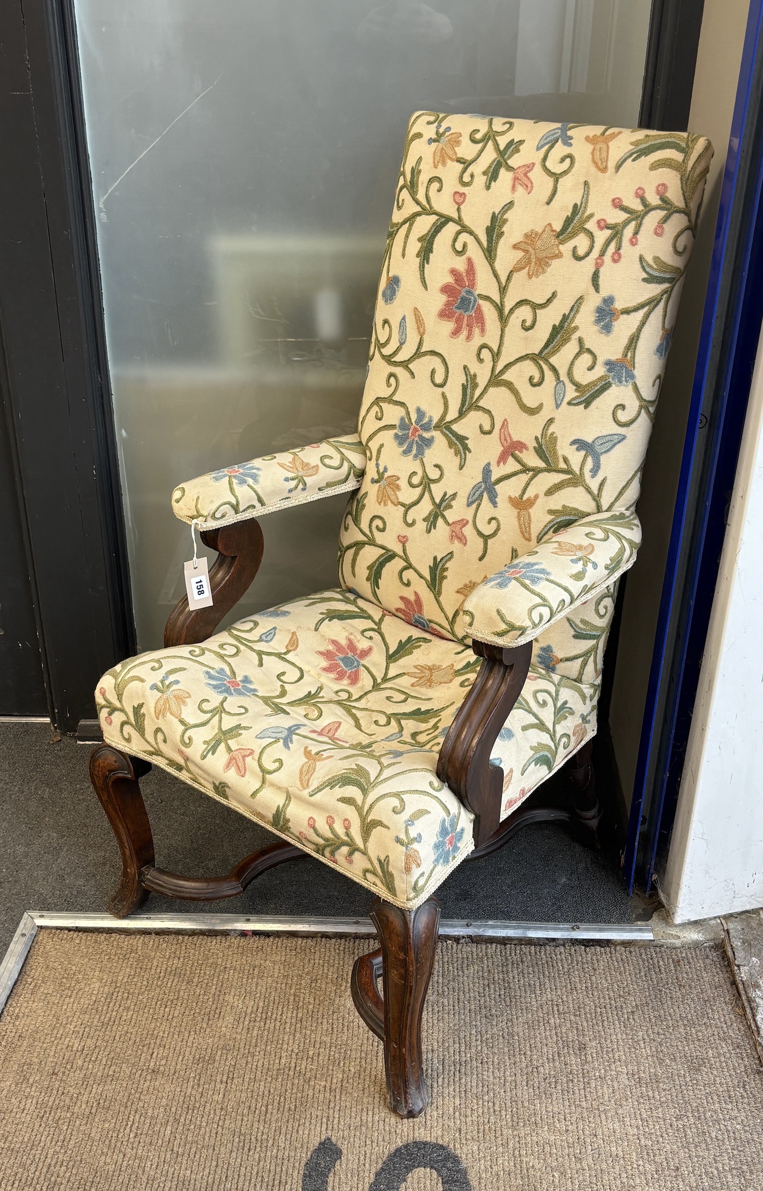 William & Mary style walnut elbow chair with crewel work upholstery on cabriole front legs with shaped X stretcher, width 58cm, depth 60cm, height 105cm.